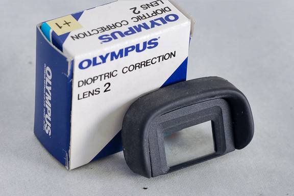 Datei:Olympus Augenkorrekturlinse +1 für OM TeamFoto.jpg